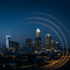 Charlotte skyline at dusk with soft glowing arcs symbolizing economic and regional growth